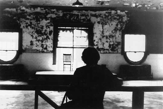 Mother revisits detention room where she was held in 1908; Ellis Island, 1980.